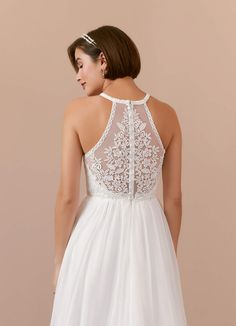 a woman wearing a white wedding dress with sheer neckline and lace detailing on the back