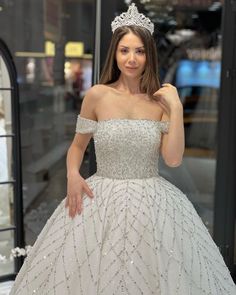 a woman in a white ball gown posing for the camera with her hand on her hip