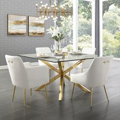 a dining room table with white chairs and a chandelier