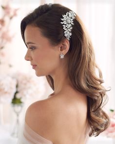 a woman wearing a wedding hair comb with flowers on it's head and shoulder