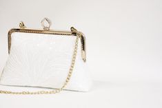 A must have accessory for elegant occasion ensembles This modern-romantic white bridal clutch purse is romance in its purest form, featuring beautiful Off-white lace with delicate sequins. The lining is beautiful silk and can be any color, secured closure with rose gold purse frame. Comes with chain or you can adding pearl handle to represent the essence of vintage romance! This clutch purse is suitable for weddings, both formal and informal party and big enough to carry all your most needed essentials.  Dimensions: Frame width : 8" (measured across the opening)  Height : 6.5" (measured across the center)  Bottom width : 9" Depth : 2" Removeable Chains : 17" Don't see what you need listed in my shop? Feel free to contact me for a special request. I love working on custom designs to match a Elegant White Bridal Accessories For Wedding, Classic White Bridal Accessories For Formal Occasion, Elegant Lace Bridal Accessories For Ceremony, Classic White Wedding Bag, Elegant White Bridal Accessories For Mother Of The Bride, Elegant White Bridal Accessories, White Bridal Accessories For Ceremony, Elegant Embroidered Bridal Accessories For Wedding, Elegant Embroidered Wedding Bridal Accessories