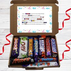 an open box filled with candy on top of a wooden table