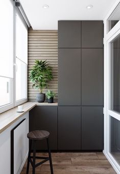 an empty kitchen with wooden flooring and gray cabinets, along with a plant on the counter