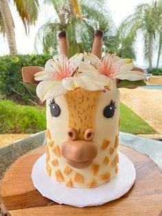 a cake with a giraffe face on it's side sitting on a table