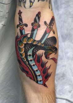 a man with a tattoo on his leg has a dragon and swords tattooed on it