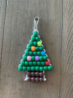 a christmas tree made out of candy on a wooden table with a keychain