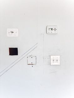 the wall is white and has several electrical outlets on it, including one for light switches