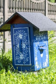 a blue and white birdhouse sitting in the grass