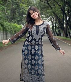 a woman is walking down the street with her arms out and hands outstretched in front of her