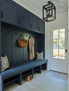 a blue bench sitting in front of a white door with shoes on it and a purse hanging from the wall