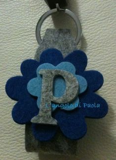 a blue flower shaped key chain with the letter d on it