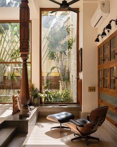 a living room filled with furniture and lots of windows next to a wall mounted fan