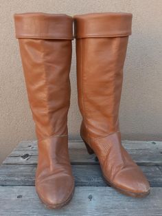 These classic 80s Frye leather boots, style C2161, are a pull-on style that features cuffed tops (can also be worn uncuffed), a buttery soft camel/tan-colored leather, and dark wooden stacked heels with a tapered shape that give these beautiful boots a rich look. The interior is constructed with a Frye fabric lining and the Frye logo is stamped on the outer ankle area of each boot. Made in the USA. Condition: These boots have done some walkin' although remain in good vintage condition. Some scra Frye Boots Women, Cuffed Top, Boots Style, Frye Boots, Thick Socks, Beautiful Boots, Leather Cuffs, Colored Leather, Stacked Heel