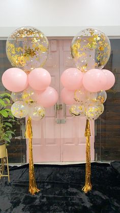 pink and gold balloons with tassels in front of a door at a party