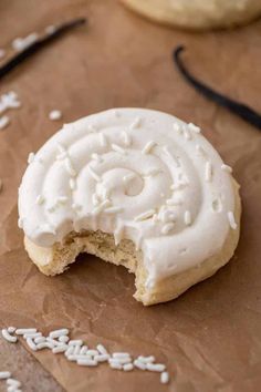 a cookie with white frosting is on a piece of brown paper