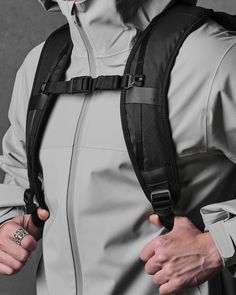 a man wearing a white and black outfit with a backpack on his back