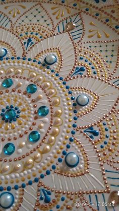 an intricately decorated plate with blue and gold beads