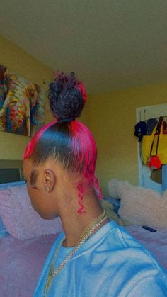 a woman with pink hair and tattoos on her head in a bedroom next to a bed