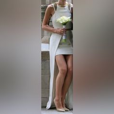 a woman in a white dress holding flowers