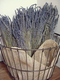 a basket filled with lavender flowers sitting on top of a wooden floor