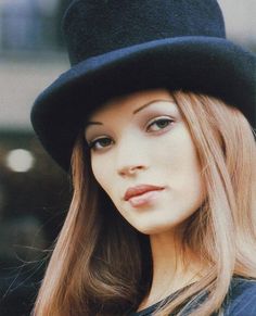 a woman with long hair wearing a black hat