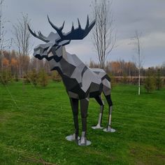 a sculpture of a stag standing on top of a lush green field