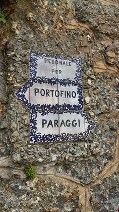 a sign on the side of a stone wall that says portofino and paraggi