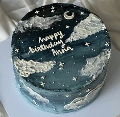 a birthday cake decorated with clouds and the words happy birthday india on it's side