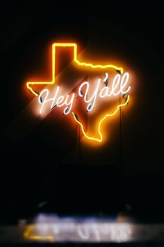 a neon sign that says hey y'alle in the shape of a texas map