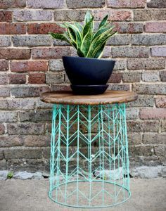 a potted plant sitting on top of a wooden table next to a brick wall