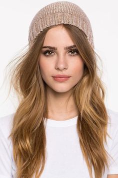 a woman with long hair wearing a beanie