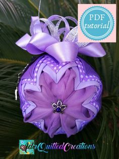 a purple ornament hanging from a tree with a bow on it's head