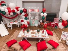 a table with red and white balloons on it in the middle of a living room