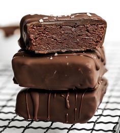 three pieces of chocolate cake sitting on top of a cooling rack next to each other