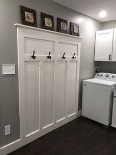 a washer and dryer in a small room with white cabinets on the wall