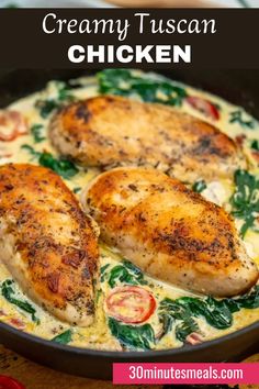 creamy tuscann chicken in a skillet with spinach and tomatoes on the side