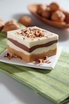 a piece of cake sitting on top of a white plate next to other plates filled with nuts