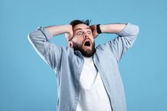 a man holding his head with both hands while looking up at something in the air