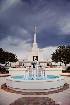 a fountain in front of a large white building