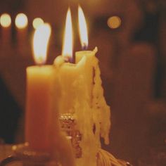 three lit candles sitting on top of a table