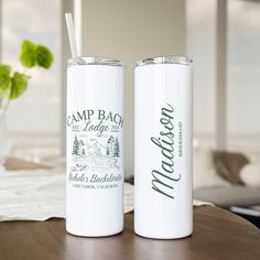 two white tumblers sitting on top of a wooden table