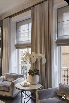 a living room filled with furniture and windows covered in draping next to each other