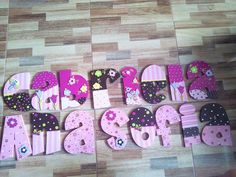 the letters are made up of pink and black polka dot material with flowers on them