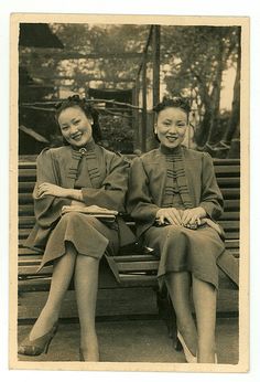 two women are sitting on a bench together