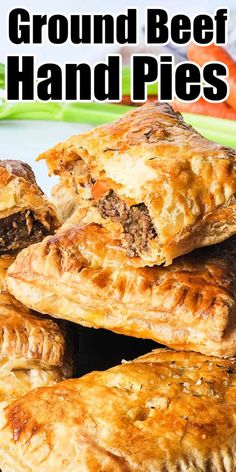 a pile of beef hand pies sitting on top of a green plate with carrots in the background