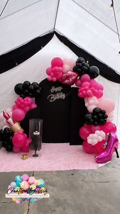 an arch made out of balloons with high heels on the floor and pink carpeted area