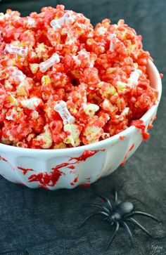 a white bowl filled with red and yellow popcorn