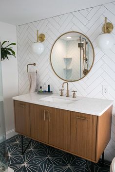 a bathroom with two sinks and a large round mirror above the sink in front of it