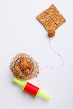 a bowl of oatmeal next to an orange and yellow straw with a red string