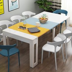 a dining table with chairs around it and a bowl of fruit on the table next to it